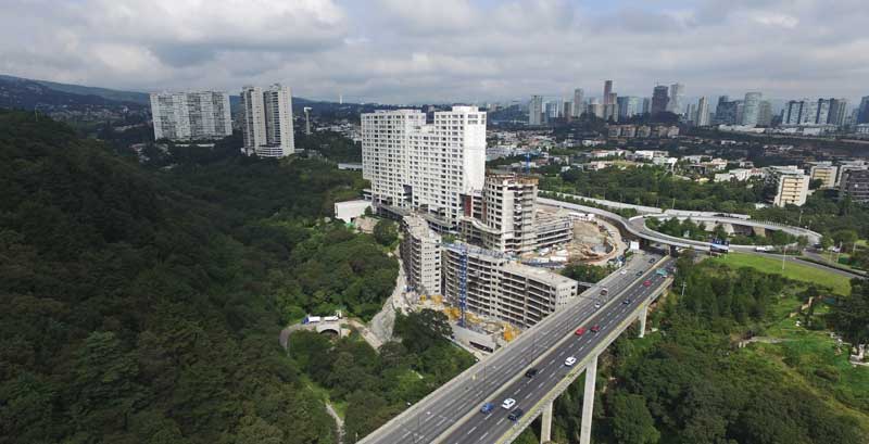 Edificio Basalto y la Supervía Poniente. Santa Fe inició con la compra y expropiación de 850 hectáreas a partir de 1987, a través de un instrumento normativo llamado Zona Especial de Desarrollo Controlado (ZEDEC) con usos de suelo y densidades.